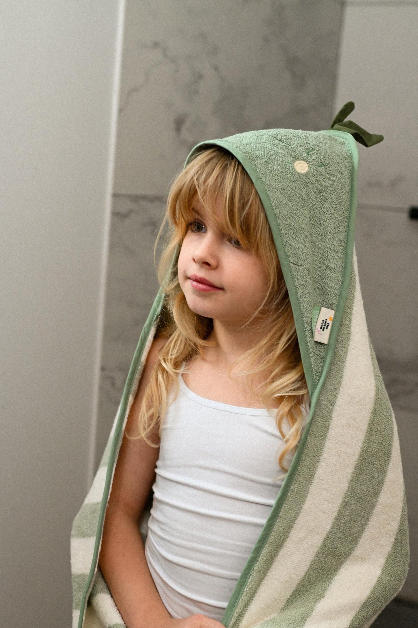 Kuscheliges Abtrocknen nach der Wanne. Das dicke Bio-Kapuzenhandtuch mit süßem Frucht-Design (Zitrone oder Birne) hält Babys Köpfchen warm.