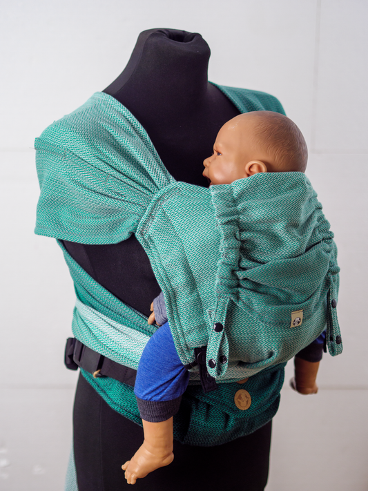 Die perfekte Mischung für den Start. Die weiche Half-Buckle Tragehilfe aus Tragetuchstoff wächst ab der ersten Lebenswoche stufenlos und ergonomisch mit.