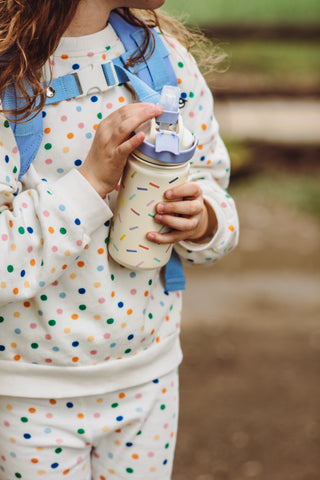 Kind hält die isolierte Kinderflasche aus Edelstahl von The Cotton Cloud in der Hand