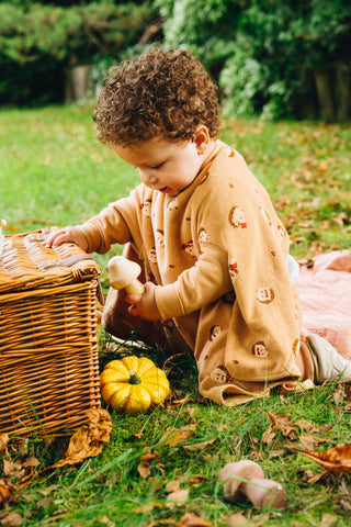 Boo Lätzchen mit Ärmeln Hedge Hugs: Kleinkind im Lätzchen neben einem Korb mit Kürbis im Herbstlaub