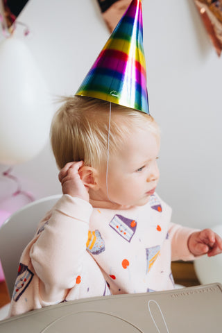 Boo Lätzchen mit Ärmeln Birthday Cake: Kleinkind mit Partyhut im Lätzchen, von der Seite