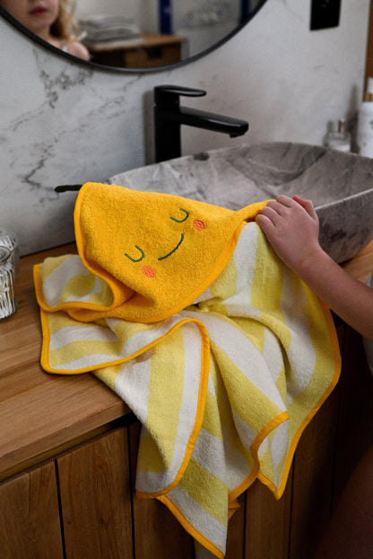 Kuscheliges Abtrocknen nach der Wanne. Das dicke Bio-Kapuzenhandtuch mit süßem Frucht-Design (Zitrone oder Birne) hält Babys Köpfchen warm.