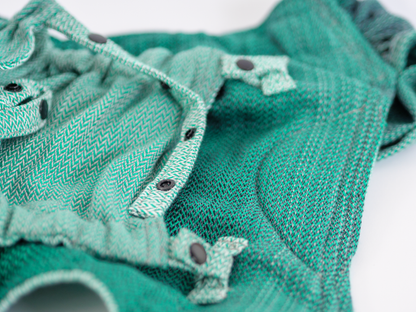 Die perfekte Mischung für den Start. Die weiche Half-Buckle Tragehilfe aus Tragetuchstoff wächst ab der ersten Lebenswoche stufenlos und ergonomisch mit.