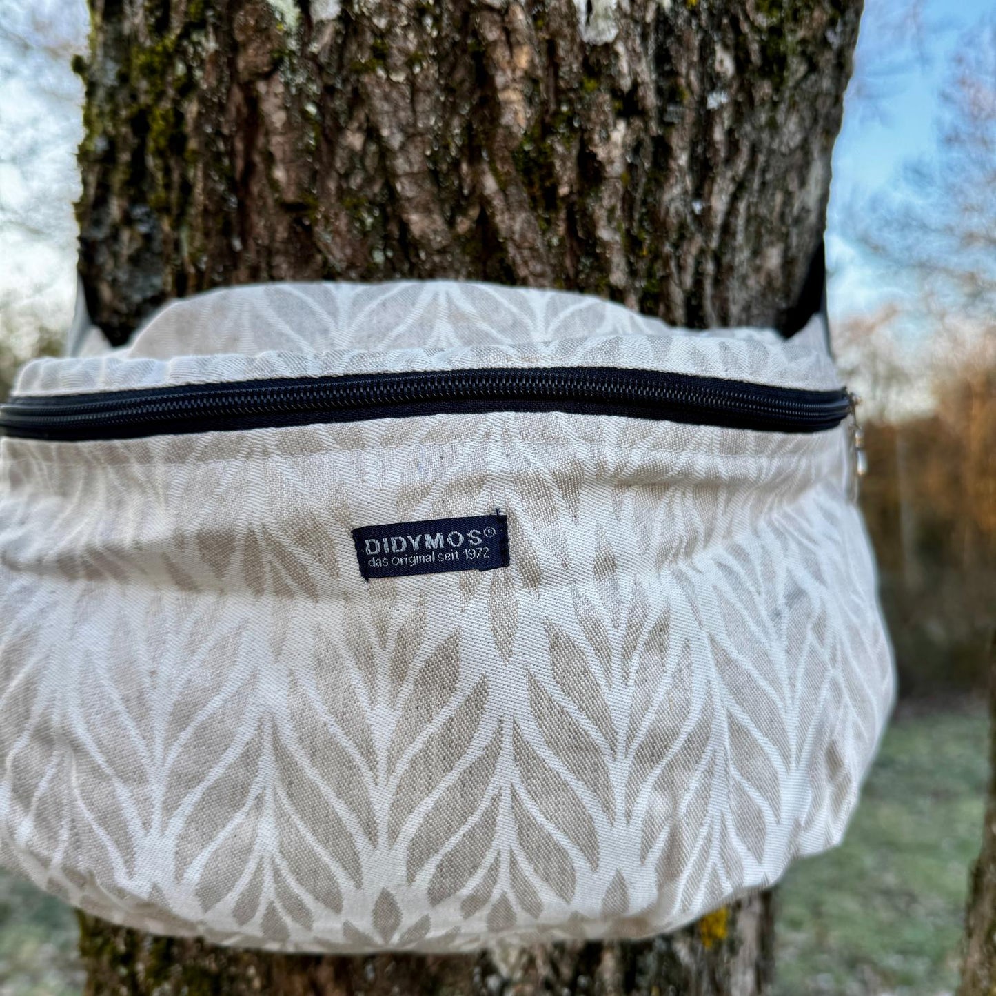 Der praktische Begleiter im Trage-Alltag! Die stylische Halbmond-Tasche bietet genügend Platz für Schlüssel, Handy und kleine Essentials, ohne zu stören.