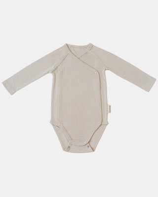 Qookie Wickelbody aus Wolle-Seide in Beige, liegend von vorn