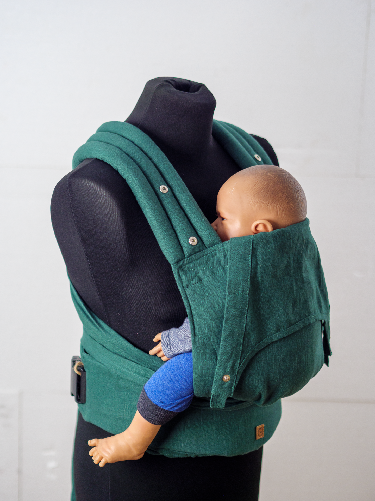 Stabiler Schnallengurt und kuschelige Bindeträger. Die stufenlos mitwachsende Half-Buckle Trage passt sich ab Geburt in Sekunden perfekt an dein Baby an.