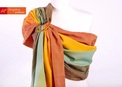 Warmer Schimmer und genialer Halt! Der handgewebte Ring Sling in den """"Gold Rainbow"""" Farben ist besonders griffig und ideal ab Geburt bis ins Kleinkindalter.""