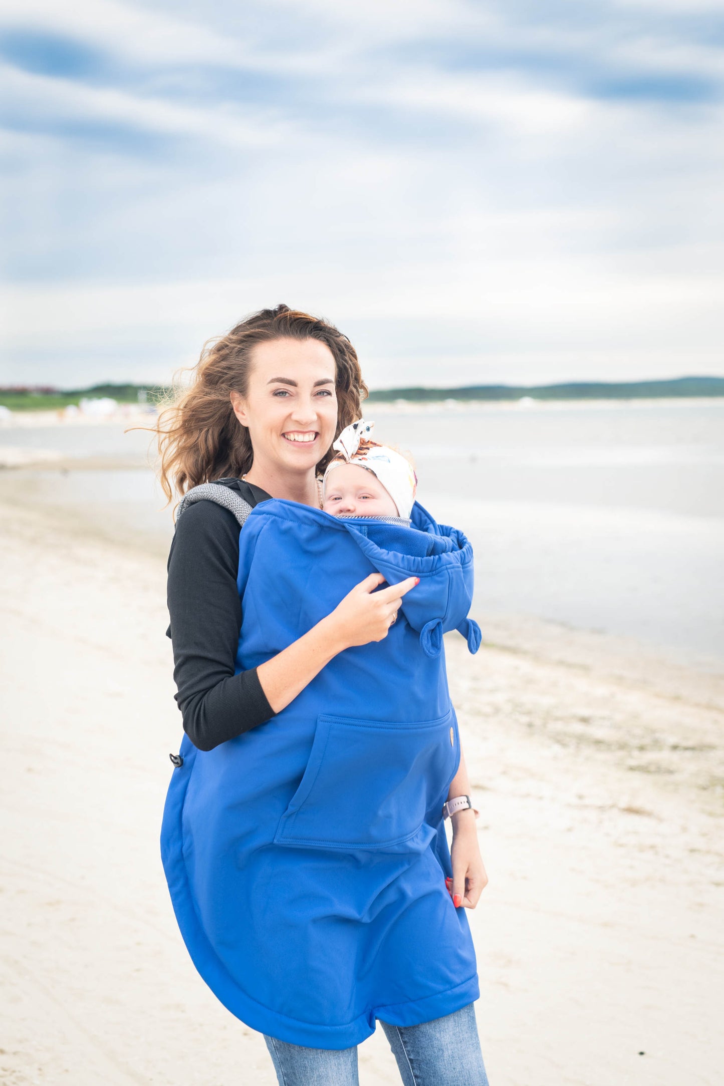 Der Wetterschutz für alle Fälle. Das gefütterte Softshell-Cover passt universell über jede Babytrage und hält dein Kind an kühlen Tagen mollig warm.