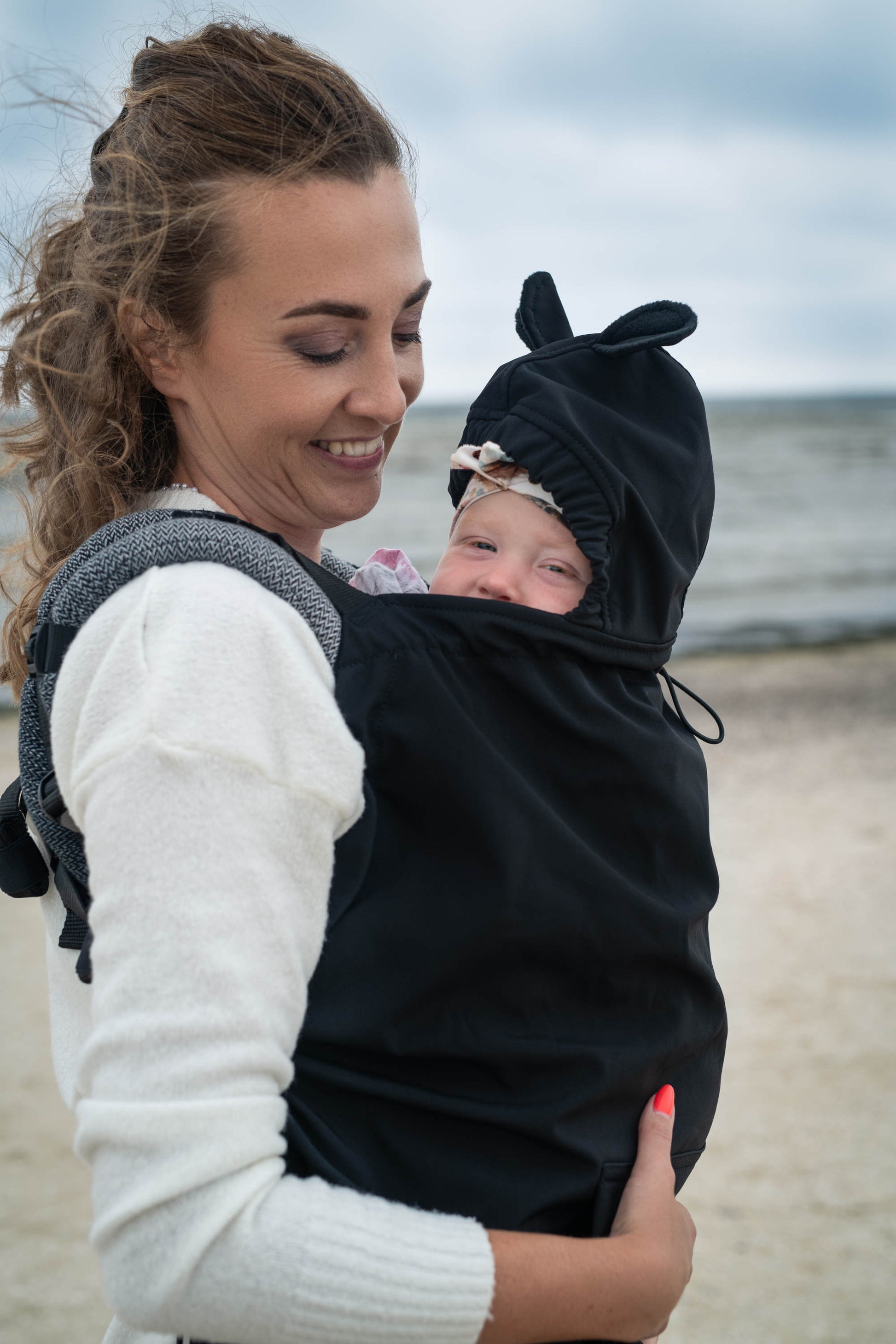 Der Wetterschutz für alle Fälle. Das gefütterte Softshell-Cover passt universell über jede Babytrage und hält dein Kind an kühlen Tagen mollig warm.