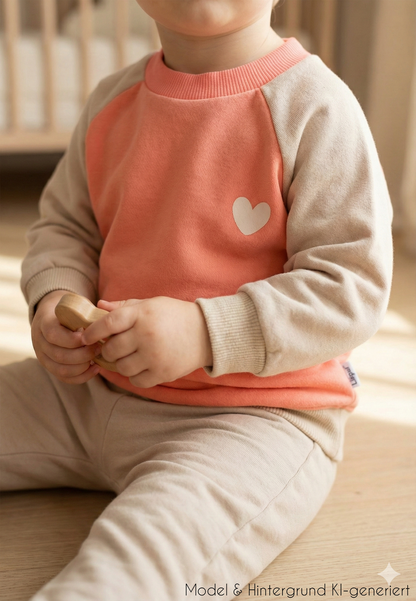 Für kleine Herzblätter! Das warme Sweatshirt in trendigem Orange und Beige mit liebevollem Herz-Print ist der perfekte Mix aus Geborgenheit und Style.