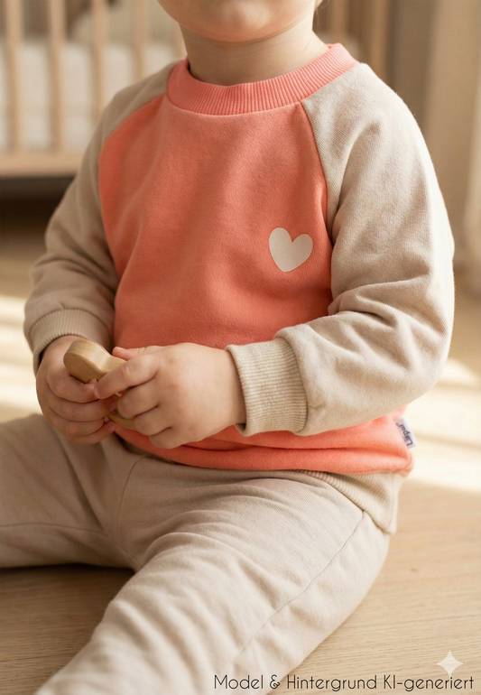 Für kleine Herzblätter! Das warme Sweatshirt in trendigem Orange und Beige mit liebevollem Herz-Print ist der perfekte Mix aus Geborgenheit und Style.