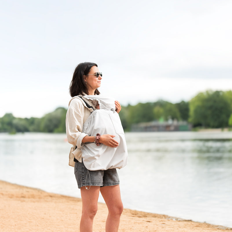 Schatten to go! Das ultraleichte UV-Schutz-Cover (UPF 50+) mit kühlendem Effekt schützt empfindliche Babyhaut im Sommer in jeder Tragehilfe.