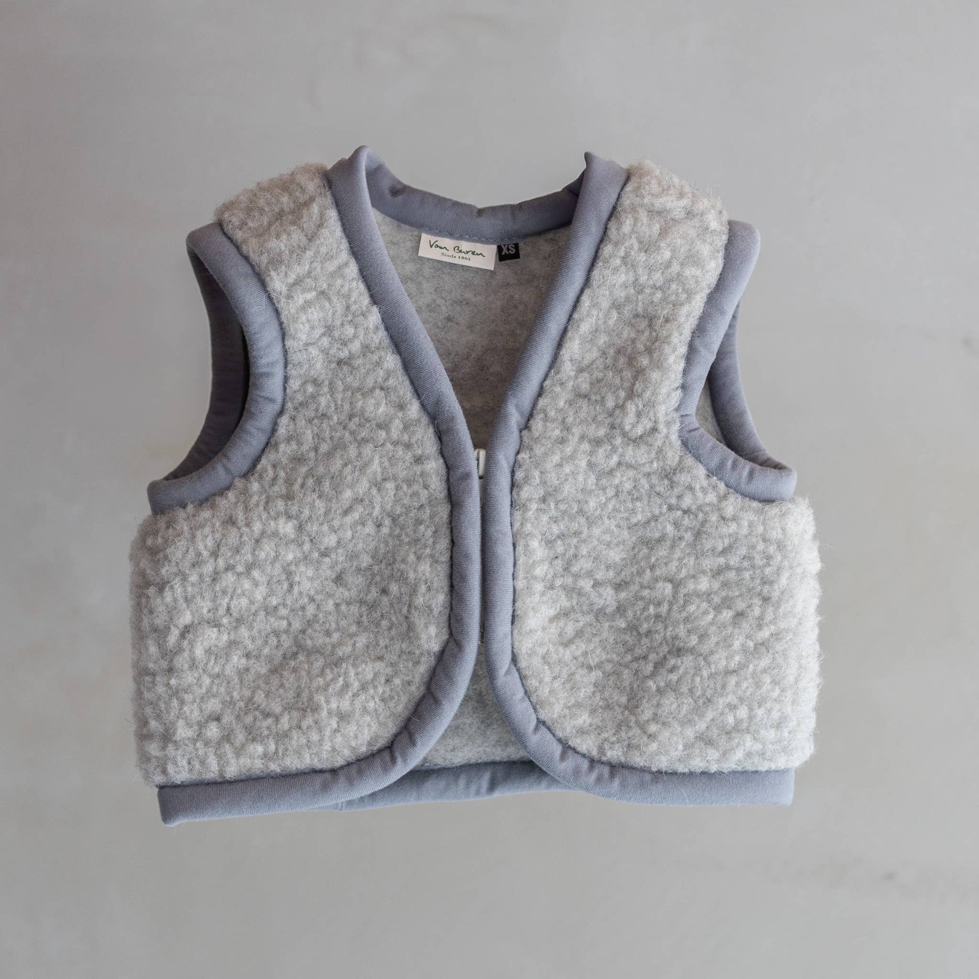 Flauschige Wärme aus der Natur! Der temperaturregulierende Bodywarmer aus 100% reiner Wolle hält dein Kind kuschelig warm, drinnen und draußen.