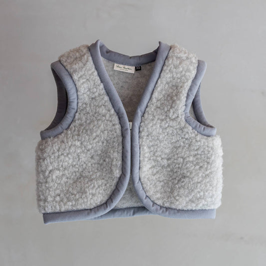 Flauschige Wärme aus der Natur! Der temperaturregulierende Bodywarmer aus 100% reiner Wolle hält dein Kind kuschelig warm, drinnen und draußen.