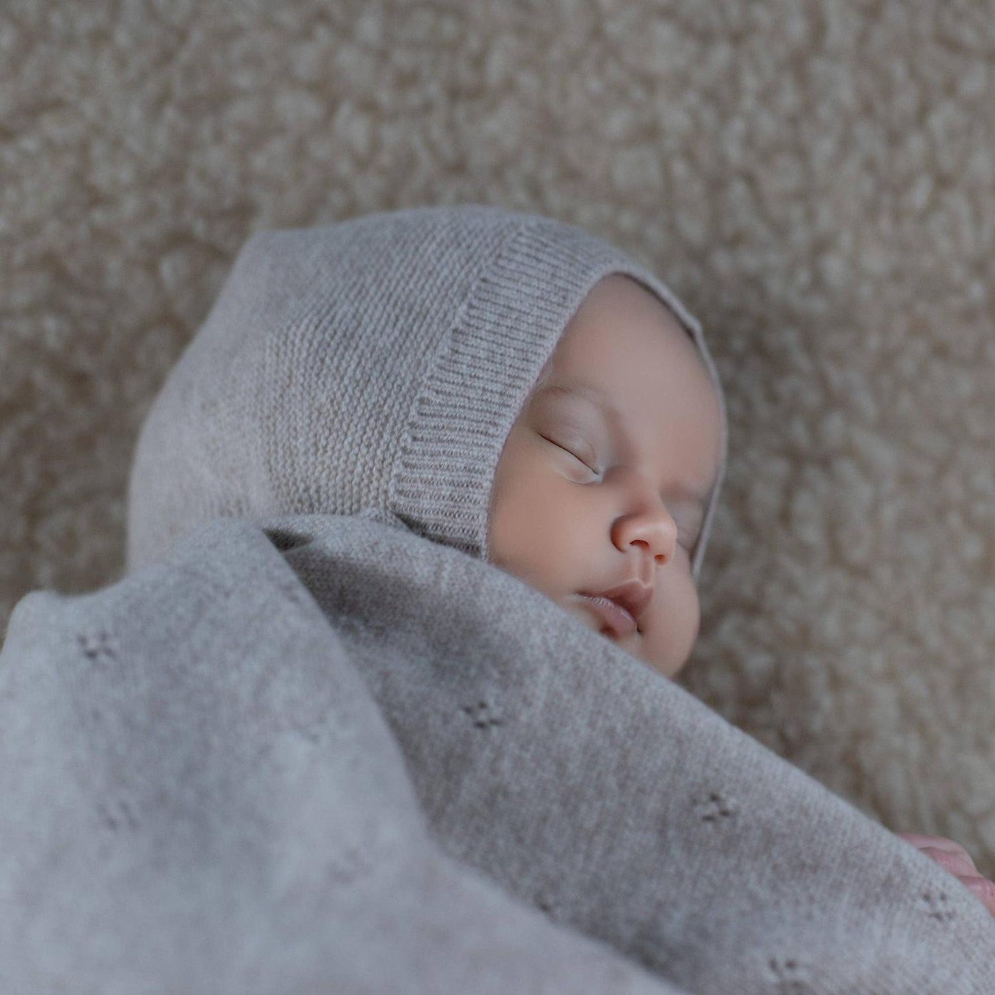 Verrutscht nicht, kratzt nicht! Die klassische Babymütze aus 100% Merinowolle schützt dank Ohrenklappen und Bindebändern perfekt vor Kälte und Zugluft.