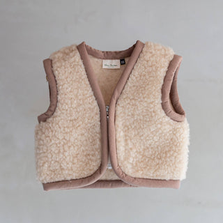 Van Buren Baby-Bodywarmer Nilo aus Wolle in Beige mit rosabraunem Saum, liegend von vorn